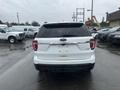 A white 2016 Ford Explorer viewed from the rear showing the tailgate and rear lights with no license plate attached