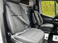 Interior of a 2020 Mercedes-Benz Sprinter displaying two gray front seats with seatbelts, designed for comfort and utility