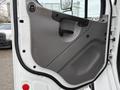 Interior door panel of a 2005 Freightliner M2 106 with a gray design featuring a handle and grip for easy opening