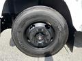 Close-up of a black tire mounted on a wheel with a shiny hub and multiple bolts indicating a heavy-duty vehicle