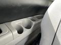 Interior view of a 2003 Mitsubishi 7 Passenger Van showing a gray cup holder console next to a textured seat