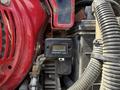 A close-up of a tachometer mounted on an engine showing the reading of 1/10 with visible wiring and components around it