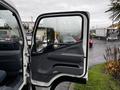 A 2012 Mitsubishi Fuso FE truck with an open driver's door showcasing the interior dashboard and seats