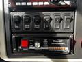 Control panel of a 2008 International 7500 featuring various switches and a Whelen traffic advisor system with indicators for left right split and flash functions