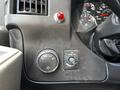 Dashboard controls of a 2013 Chevrolet Express showing various dials for lights and a red emergency button