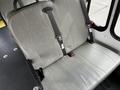 Interior of a 2016 Ford Econoline showing gray vinyl seating with seatbelts on both sides