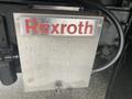 Metal box with the name "Rexroth" engraved on the front connected to a vehicle's hydraulic system