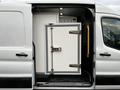 A 2020 Ford Transit with a side door open revealing a white insulated compartment with a lock and metal handles