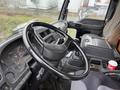 Interior view of a 2006 GMC F7B042 truck showing the steering wheel dashboard and gear shift with a coffee cup on the console