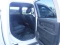 A white 2019 RAM 1500 Classic Eco Diesel with a view of the rear interior showing two black leather seats and a black door panel