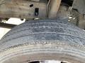 Close-up of a weathered tire on a 2003 Ford F-450 SD showing visible tread wear and potential damage to the sidewall