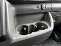 A close-up view of the center console in a 2023 Ford Transit featuring two cup holders a USB port and a 12V power outlet