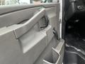 Interior door handle and armrest of a 2018 Chevrolet Express with a storage compartment and controls visible