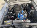 A 1966 Ford Mustang engine bay featuring a black air cleaner and blue engine block with visible wiring and components