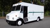 A white 2004 Freightliner MT45 delivery truck with a green stripe and amber lights on the roof parked at an angle