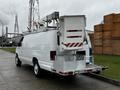 A white 2009 Ford Econoline van with a ladder rack and utility box mounted on the rear, parked on a pavement