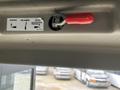 A red handle for releasing or engaging a mechanism located on the interior of a 2017 Chevrolet Express with a warning label above it