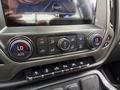 Controls and display screen of a 2017 Chevrolet Silverado 1500 featuring climate control buttons and driver assistance functions