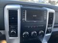 Dashboard of a 2011 RAM 1500 featuring a central display screen with controls for radio and climate settings along with various knobs and buttons