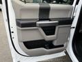 Interior door panel of a 2017 Ford F-450 Super Duty featuring a handle and storage compartment in a two-tone design