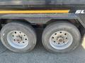 Two worn wheels of a 2024 Southland 18 Foot Dump Trailer featuring silver rims and visible brake components