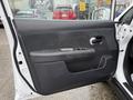 Interior door panel of a 2012 Nissan Versa featuring a black armrest a window control panel and a door handle