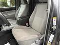 Interior view of a 2015 Toyota Tacoma showing two front seats with gray upholstery and a center console