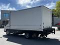 A 2018 Hino 195 box truck in white with a clean cargo area and side door features visible with a single rear axle and black bumper