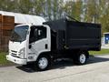 A white 2016 Isuzu NPR with a black dump truck bed parked on a paved surface