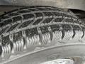 Close-up of a tire tread from a 2014 Chevrolet Express showing deep grooves and wet surface indicating recent use or exposure to moisture