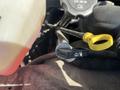 Close-up of a 2013 Chevrolet Express engine with a yellow dipstick and a fluid reservoir showing a red liquid inside