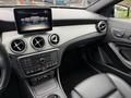 Interior view of a 2016 Mercedes-Benz GLA-250 featuring a central touchscreen display and a sleek dashboard with air vents and leather seats