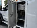 A 2016 Ford F-550 with an open service body featuring shelves and compartments for tools and equipment
