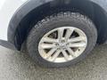 A close-up of a 2016 Ford Explorer's wheel and tire showing silver alloy rims and a rugged tread pattern on the tire