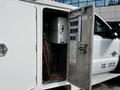 A 2016 Ford F-550 with an open door revealing equipment cables and controls inside the compartment