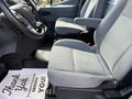 A 2016 Ford Transit interior with two gray seats visible in the foreground and a steering wheel partially shown