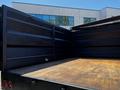 A 2015 RAM 5500 truck bed with an open tailgate showing a wooden floor and black metal sides
