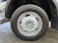 A close-up view of a silver wheel with a polished rim and black tire on a 2012 Dodge Ram 5500