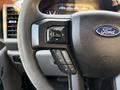 Close-up of the steering wheel of a 2018 Ford F-350 SD featuring control buttons on the left side and a Ford emblem in the center