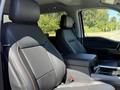 Interior view of a 2024 Ford F-550 Super Duty showcasing the driver's and passenger's seats with black leather upholstery and a center console