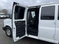 A 2012 Chevrolet Express van with the passenger door open showcasing the interior seating and floor space