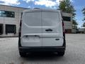 A white 2014 Ford Transit Connect van viewed from the rear with a plain tailgate and missing license plate holder