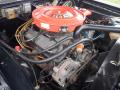 A close-up view of a 1974 Dodge Challenger engine featuring a red air cleaner labeled 360 with various components including hoses and an alternator visible