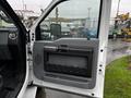 Interior door panel of a 2014 Ford F-550 featuring a gray design with a black handle and storage area