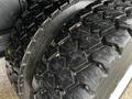 Close-up of the tire of a 2013 Ford F-650 showcasing a rugged tread pattern with visible water and dirt particles on the surface