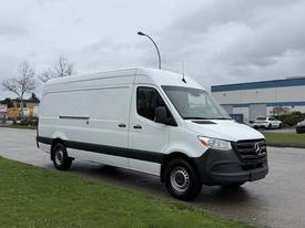A 2019 Mercedes-Benz Sprinter van with a white exterior and black accents parked on a road