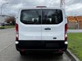 A white 2023 Ford Transit van viewed from the rear with large taillights and a rectangular back door