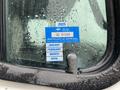 A blue and white certificate of approval sticker attached to a wet window of a 2003 Freightliner M2 106 with various months listed and marked