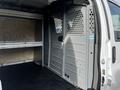 Interior of a 2015 Chevrolet Express van showing metal partition and storage shelves with a solid floor