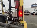 A yellow Hyster 120 forklifts rear light is glowing red with controls visible in the foreground